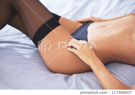 Woman, stomach and lingerie in bedroom for relax, body and seduction with comfort in apartment. Female person, underwear and sexy in home with confidence for figure, skin and summer in New York Woman, stomach and lingerie in bedroom for relax, body and seduction with comfort in apartment. Female person, underwear and sexy in home with confidence for figure, skin and summer in New York 117468607