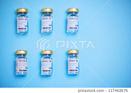 Medical, Covid vaccine and bottle in studio, innovation in health care for pandemic. Blue background, glass container and medicine with research for virus, chemistry development for human wellness 117468676