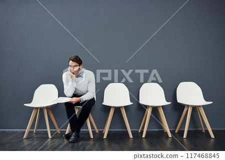 Waiting room, thinking and business man for recruitment, hiring or job interview in office. Chair, bored and male person as candidate of human resources, tired or impatient with paper by mockup space 117468845