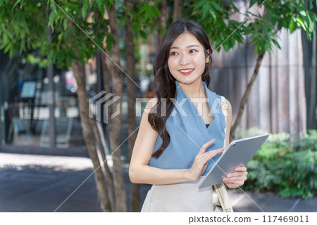 Businesswoman holding a tablet device in an office district 117469011