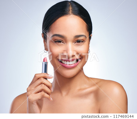 Cosmetics, lipstick and woman in portrait for beauty, makeup and facial product in grey studio background. Female person, happy or dermatology with pink lips for confidence, and glamour or skincare 117469144