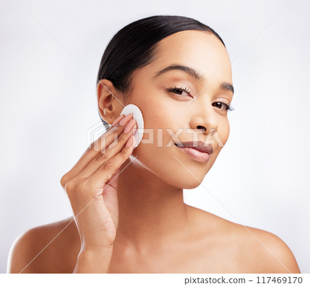 Studio, portrait and woman with cotton for skincare, makeup removal and cleansing for wellness. Female model, cosmetics and products for cleaning, facial treatment and swab pad by white background 117469170
