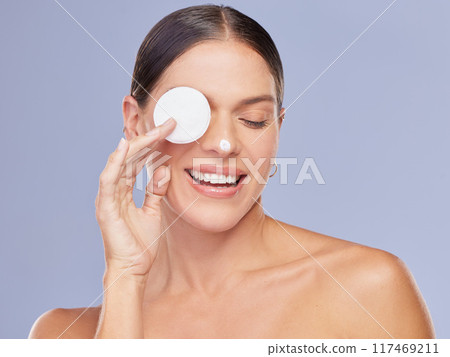 Face cream, cotton and woman in studio for skincare, cleaning and wellness, hydration or foam cleaner on blue background. Beauty, toner and girl model with makeup pad for facial, exfoliate or mask 117469211