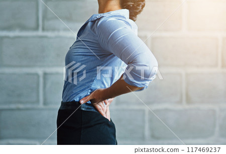 Business, woman and sore with back pain by brick wall for muscle tension, fatigue and work injury. Corporate, professional and female person with problem in health for strain, stress or ache in spine 117469237