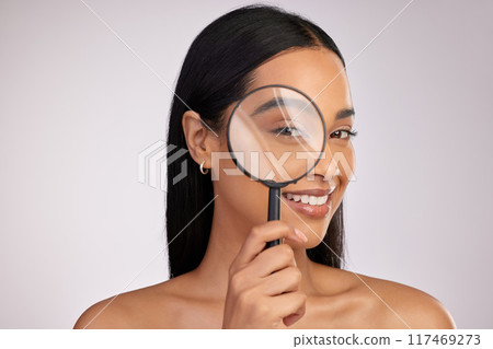 Portrait, woman and magnifying glass in studio for skincare, fine lines and beauty routine. Investigation, pride and cosmetics with treatment, wellness and collagen for wrinkles by white background 117469273