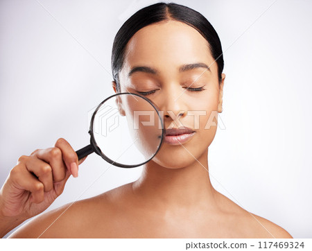 Skincare, woman and magnifying glass for beauty with confidence, pride for dermatology on white background. Female person, cosmetic and results with eyes closed, face in studio for wellness or glow 117469324