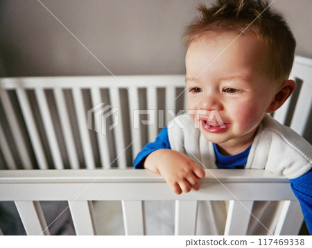 Cute, happy and baby in family home crib for child development, fun and thinking. Toddler, sweet and playful for cheerful gentle boy relaxing on a bed in his nursery or innocent bedroom cradle Cute, happy and baby in family home crib for child development, fun and thinking. Toddler, sweet and playful for cheerful gentle boy relaxing on a bed in his nursery or innocent bedroom cradle 117469338