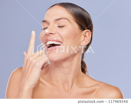 Woman, nose and apply cream in studio for skincare, ointment and spf or cosmetics on blue background. Person, lotion and laugh for dermatology, glow and moisturizer for hydration or skin treatment Woman, nose and apply cream in studio for skincare, ointment and spf or cosmetics on blue background. Person, lotion and laugh for dermatology, glow and moisturizer for hydration or skin treatment 117469348