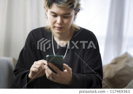 A young man operating a smartphone A young man operating a smartphone 117469363