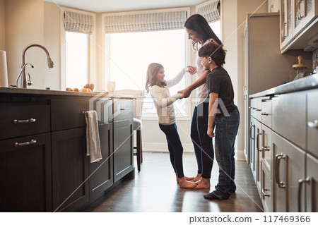 Love, dance or mother and children in a kitchen for fun, learning and holding hands with trust, care or support at home. Balance, feet and woman with kids in a house for bonding with radio music 117469366