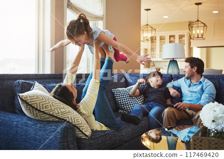 Airplane, funny and family on sofa in home relaxing with care, happiness and love together. Smile, bonding and girl child with flying and playing with mom, brother and dad or people on couch in house Airplane, funny and family on sofa in home relaxing with care, happiness and love together. Smile, bonding and girl child with flying and playing with mom, brother and dad or people on couch in house 117469420