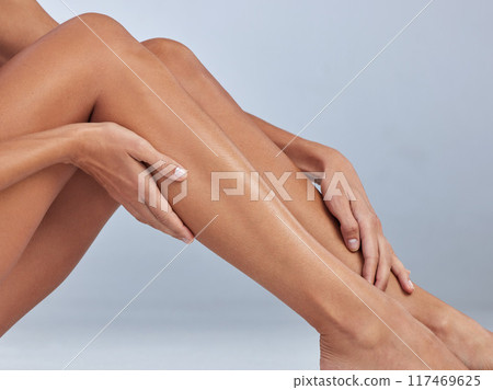 Woman, legs and soft in studio for epilation, skincare and hair removal on blue background. Female person, beauty and waxing or shaving for clean glow, grooming and cosmetics or dermatology smooth Woman, legs and soft in studio for epilation, skincare and hair removal on blue background. Female person, beauty and waxing or shaving for clean glow, grooming and cosmetics or dermatology smooth 117469625