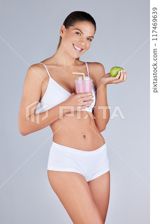 Apple, portrait and woman with smoothie for nutrition, diet and detox or confidence in studio. Wellness, fitness and model girl with fruit or protein shake for workout and breakfast for weight loss 117469639