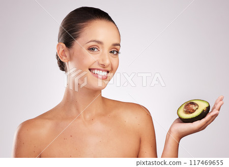 Skincare, woman and avocado in studio with portrait for anti aging, moisturize or glowing skin on white background. Wellness, fruit and hand of model for omega 3, dermatology or organic cosmetics Skincare, woman and avocado in studio with portrait for anti aging, moisturize or glowing skin on white background. Wellness, fruit and hand of model for omega 3, dermatology or organic cosmetics 117469655