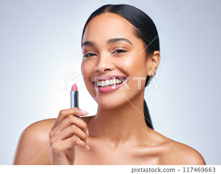 Cosmetics, lipstick and woman in portrait for beauty, makeup and facial product in grey studio background. Female person, happy or dermatology with pink lips for confidence, make over and glamour 117469663