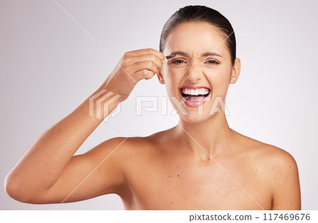 Woman, tweezers and eyebrow in studio for grooming, pain and hair removal or epilation on white background. Female person, skincare and tool for maintenance or clean, beauty and cosmetics for shape 117469676