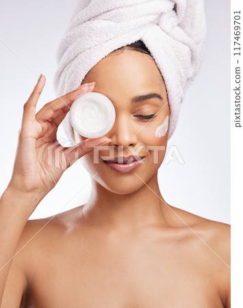Skincare cream, hand and woman in studio with eyes closed for cosmetics, natural glow or treatment on white background. Towel, body and model with product for satisfaction, dermatology or moisturizer 117469701