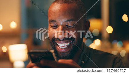 Face, laughing and phone with black man in home at night for communication, meme or networking. Comedy, funny and humor with person reading text message on mobile in apartment for social media 117469717