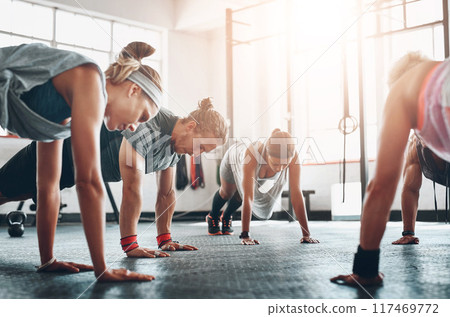 Group, fitness class and exercise with push ups in gym for arm strength, healthy body and wellness. Training collaboration, people and muscle challenge for core, weightloss and physical activity 117469772