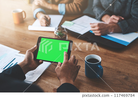 Tablet, green screen and business meeting at table with collaboration, planning for company pitch. Mobile technology, people and chroma key with hands for logo, review or mock up for accounting 117469784