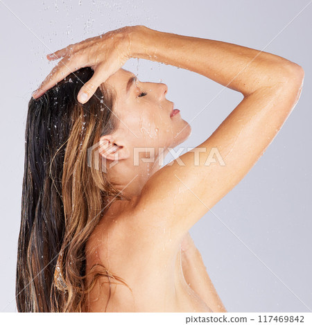 Woman, shower and washing in studio for moisture, cleaning and shower for cosmetics or hygiene. Female person, skincare and grooming on white background, beauty and refreshing liquid for pamper 117469842