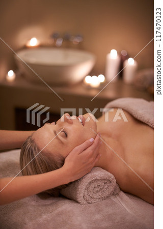 Face massage, spa and relax with woman, beauty and candles with hospitality and stress relief. Person, facial and girl with wellness or healthy with vacation or peace with holiday, detox or self care 117470123