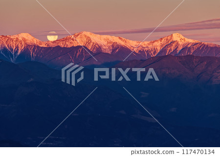The full moon setting over the Shiramine Sanzan mountains at sunrise as seen from Mount Ryugatake 117470134