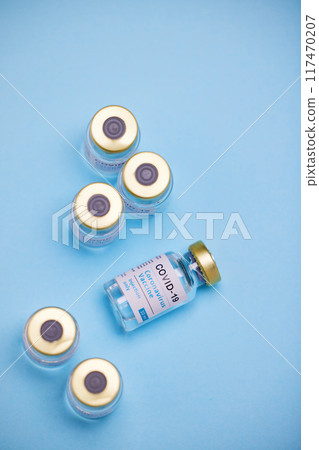 Medical, Covid vaccine and bottle in studio, innovation in health care for pandemic. Blue background, glass container and medicine with research for virus, chemistry development for human wellness Medical, Covid vaccine and bottle in studio, innovation in health care for pandemic. Blue background, glass container and medicine with research for virus, chemistry development for human wellness 117470207