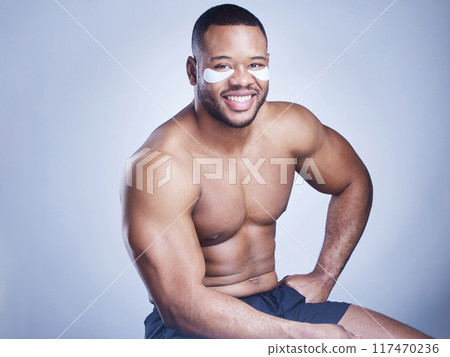 Black man, portrait and eye pads in studio, facial treatment and hydration mask on blue background. Male person, skincare and beauty product for moisture, grooming and patches to smile for cosmetics 117470236