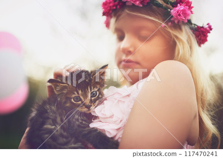 Girl, care and outdoor with kitten for love or furry companion for comfort, friendship and growth or development. Kid, flower crown and cute animal in nature with affection, bonding and playing. 117470241