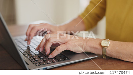 Senior hands, laptop and typing at table, working or download on Internet for retirement budget. Person, fingers and computer at desk for online research, email plan for financial wellness at home 117470474
