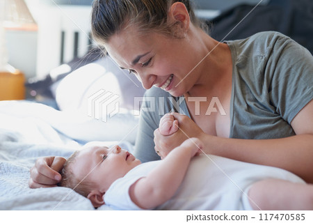 Mom, baby and forehand kiss on bed in home for support, love and care for growth and child development. Parent, kid and happy in bedroom with playing for bonding, childhood memories and toddler 117470585