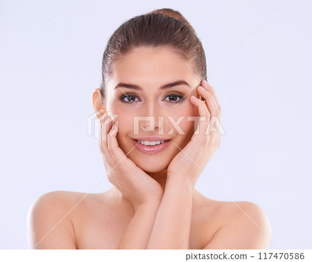 Woman, hands on skin and portrait for beauty, happy with facial and wellness for dermatology on white background. Antiaging, treatment and makeup cosmetics for skincare, smile and shine in studio 117470586