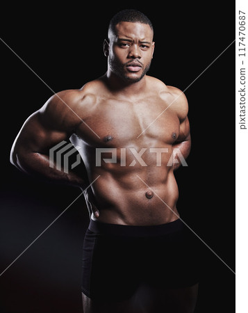 Black man, portrait and abdomen in studio for exercise, strong bodybuilder or training for wellness. Male athlete, dark background or confidence for topless workout, stomach with muscle for gym sport 117470687