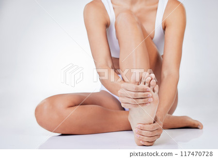 Woman, foot massage and body care for cosmetics, skincare and pain relief in white studio background. Female person, feet and sprain touching for health, wellness and rubbing or tension removal Woman, foot massage and body care for cosmetics, skincare and pain relief in white studio background. Female person, feet and sprain touching for health, wellness and rubbing or tension removal 117470728