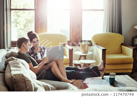 Couple, laptop and relax in lounge, bills and document of loan, marriage and home in weekend and morning. House, man and woman on sofa, paperwork and together in living room, couch and happiness 117470749