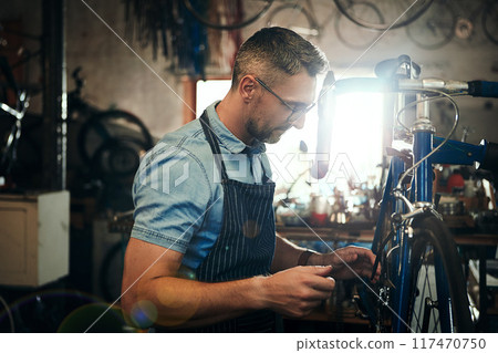 Man, bicycle and mechanic with wheel for repair, fix or maintenance at indoor workshop. Young male person, cycle technician or bike engineer working on cycling vehicle, gears or hardware at shop Man, bicycle and mechanic with wheel for repair, fix or maintenance at indoor workshop. Young male person, cycle technician or bike engineer working on cycling vehicle, gears or hardware at shop 117470750