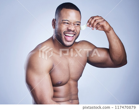 Black man, lifting and eye patch in studio, facial treatment and hydration mask on blue background. Male person, skincare and beauty product for moisture, grooming and pads to pamper or cosmetics 117470879