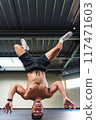 Latino man doing a breakdance pose with his shirt off 117471603