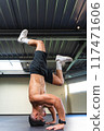 Latino man learning how to do a handstand at the gym 117471606