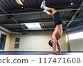 Shirtless latin man doing a handstand at the gym 117471608