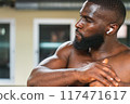 Black athlete stretching muscles in the sports center 117471617