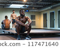 Black personal trainer watching his student train 117471640