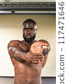 Shirtless black man stretching his wrists before a workout 117471646