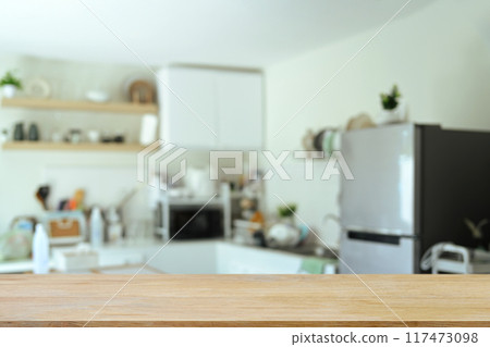 Empty wood table with blurred kitchen room in background, space text or showcasing products 117473098
