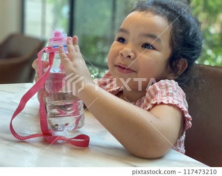 asian child girl playing water on the table asian child girl playing water on the table 117473210