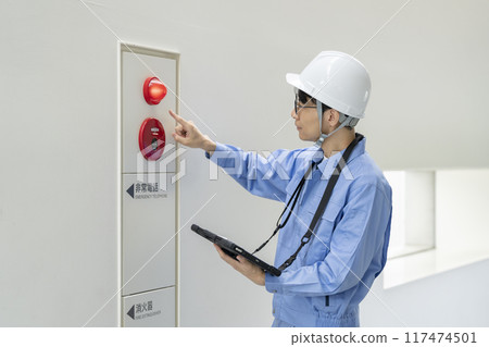 一名穿著工作服的男子檢查火警、建築維護圖像 一名穿著工作服的男子檢查火警、建築維護圖像 117474501