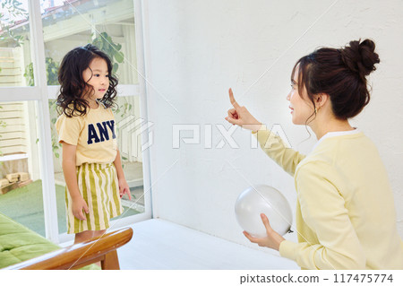 Parent and child playing in the living room 117475774