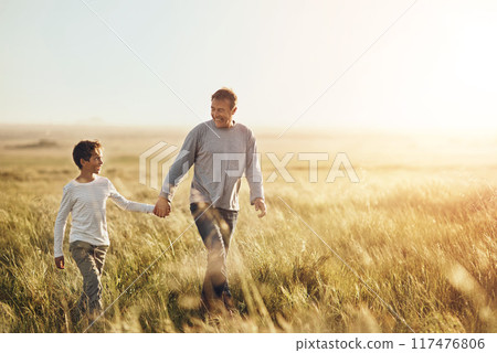 Holding hands, walking and father with child in nature at sunset for bonding together on vacation. Happy, farm and dad with boy kid on adventure, holiday or weekend trip in agriculture countryside. 117476806