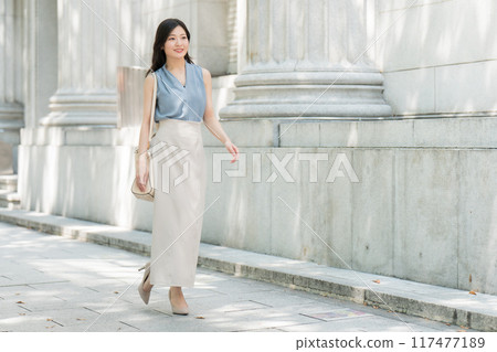 Businesswoman walking in the city 117477189